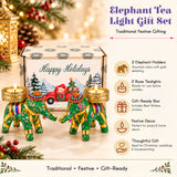 Gift box with green elephant-shaped tea light holders featuring gold accents and colorful floral patterns for festive gifting