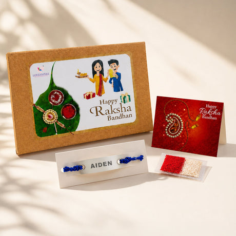 Personalized stainless steel name rakhi with blue thread and silver plate engraved aiden displayed on white stand