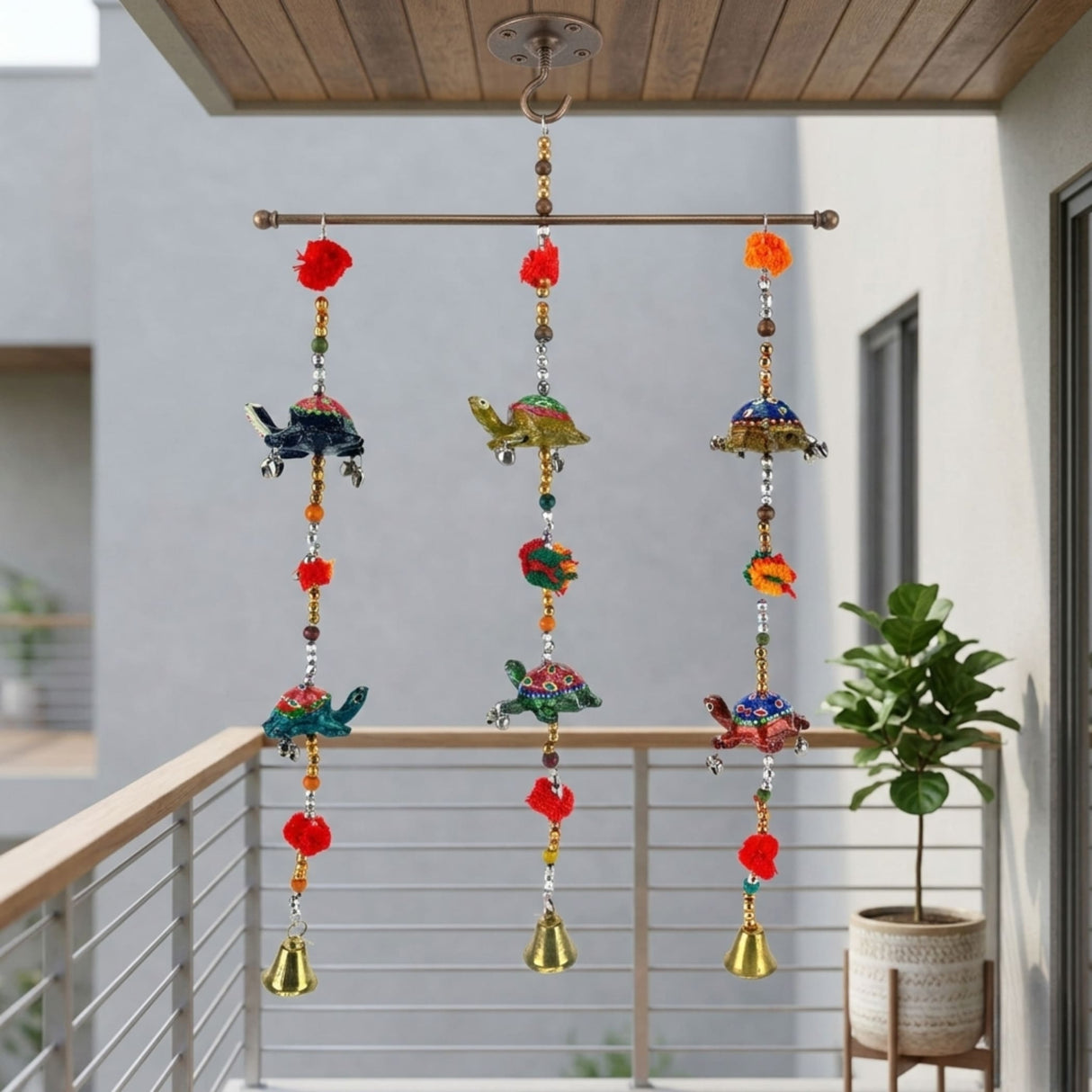 Colorful hand-painted Rajasthani turtle wind chime with red pom-poms, golden bells