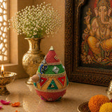 A vibrant beaded ganesha-shaped shriphal mangal kalash decorated coconut with red green gold patterns and rhinestones for wedding pooja