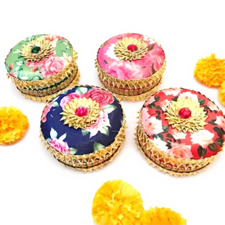 Decorative floral fabric-covered trinket box with gold trim and red gemstone center