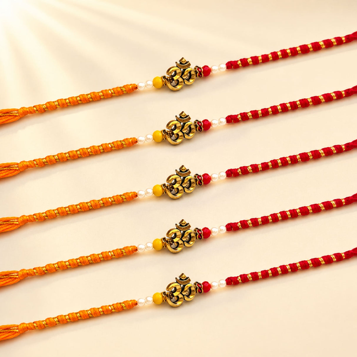 Five traditional orange and red handcrafted designer om rakhi bracelets with golden om charms white pearls and yellow beads for raksha bandhan