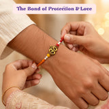Gold-colored om charm bracelet with red orange and white beads handcrafted adjustable thread for raksha bandhan gift