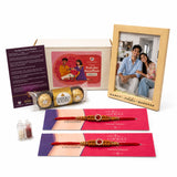 Designer rakhi gift hamper featuring red and gold rakhi with a central red gemstone for Raksha Bandhan celebration