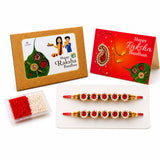 Two ornate red and gold rakhi threads adorned with sparkling stones for brother and bhabhi traditional gift set