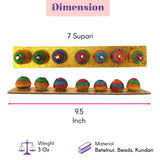 A vibrant handcrafted decorative designer supari betelnut set with seven colorful beads on an ornate golden base for pooja