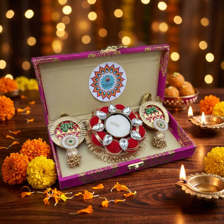 A decorative red and gold diwali diya set with crystal embellishments in a purple brocade gift box for festive celebration
