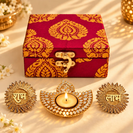A maroon and gold brocade fabric box with metallic clasp in a diwali gift hamper for traditional festive celebration