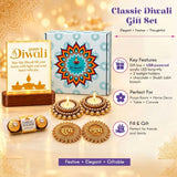 The Diwali gift hamper features a light-up happy Diwali plaque with gold lettering and an illuminated diya on a dark wood base