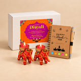 Red elephant-shaped tealight candle holders with intricate gold and green embroidery in Diwali gift hamper