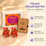 Red elephant-shaped tealight holders with intricate gold and green embroidery in a diwali gift hamper set