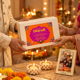 A white rectangular gift box with an orange and purple happy diwali label in a festive indian diwali gift hamper set
