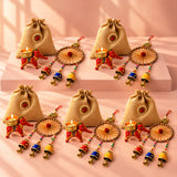 Beige jute drawstring bags with red and gold decorative elephant candle holders for Diwali and festive gift hampers
