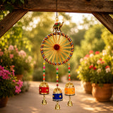 A vibrant handcrafted wind chime with a golden wheel and multicolored spokes in a diwali gift hamper jute potli bag