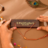 Brown wooden plaque with orange thread bracelets and silver beads for Durga Chalisa