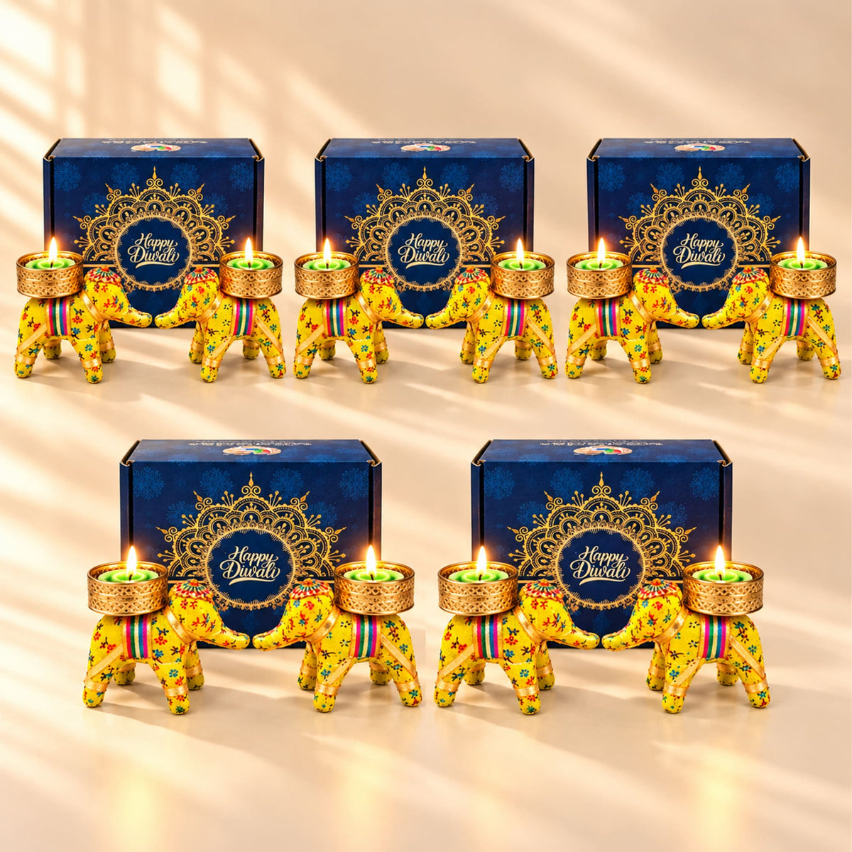Yellow elephant-shaped Diwali candle holders with intricate floral patterns and gold-trimmed bases holding lit green tea lights