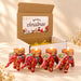 Red elephant-shaped tealight candle holders with intricate gold and colorful embroidery in a festive gift box