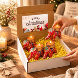Gift box with four red elephant-shaped tealight candle holders featuring intricate gold and green patterns for festive gifting