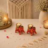 Two vibrant red elephant-shaped candle holders with intricate gold and green patterns for diwali and home decor