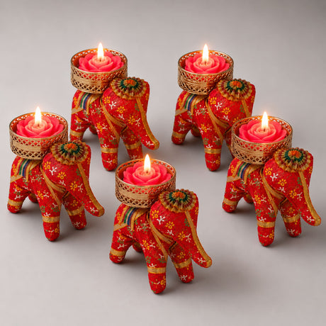 Red elephant-shaped tea light candle holders with gold trim and floral patterns holding pink rose-scented candles for diwali and home décor