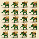 Green elephant-shaped tealight holders with gold and purple decorative accents for festive home decor and gifting