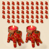 Red elephant-shaped tea light candle holders with gold floral patterns cradling pink rose wax candles for festive decor