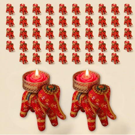 Red elephant-shaped tea light candle holders with gold floral patterns cradling pink rose wax candles for festive decor