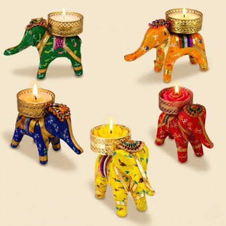 Colorful intricately embroidered elephant tea light candle holders with golden accents lit for diwali or festive decor
