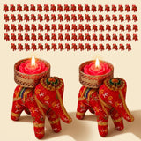 Red elephant-shaped tea light candle holders with gold floral embroidery cradling pink rose wax candles for diwali home decor