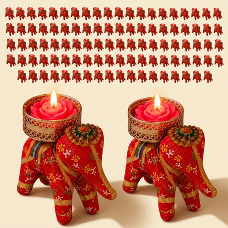 Red elephant-shaped tea light candle holders with gold floral embroidery cradling pink rose wax candles for diwali home decor
