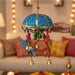 A vibrant blue and gold elephant umbrella door hanging with colorful beaded tassels and golden bells for traditional decor