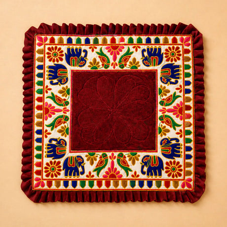 A rich maroon velvet elephant pooja aasan rug with embroidered blue elephants and floral motifs for Ganesh pooja
