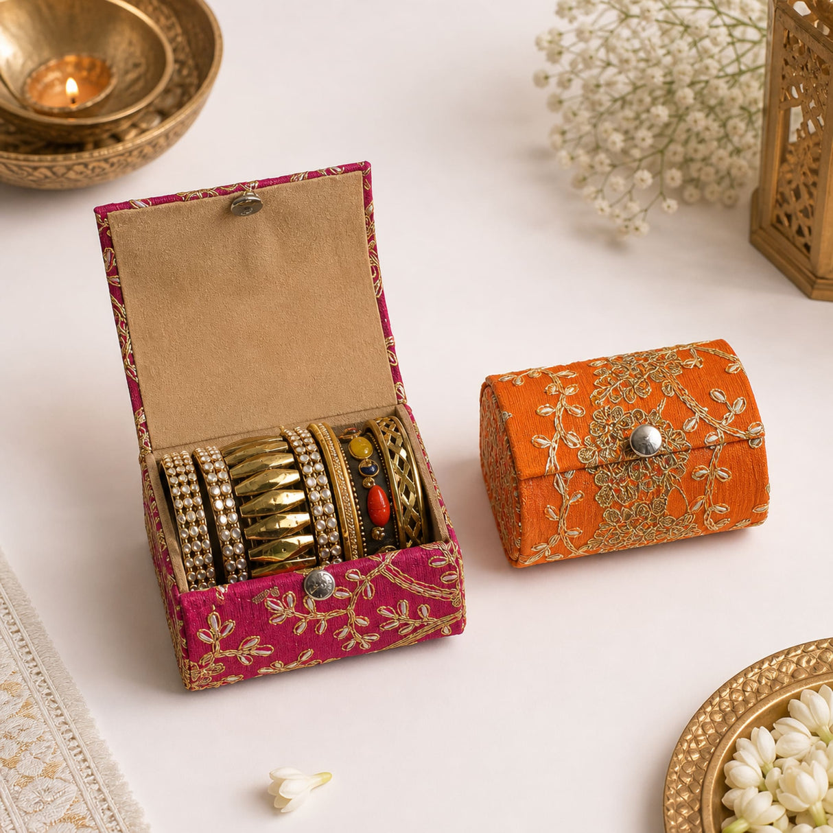 Vibrant pink and orange embroidered bangle organizing box with metallic clasps holding gold-toned jewelry for women and girls