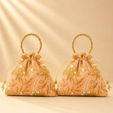 Peach-colored designer potli bag with gold beaded handles pearl accents embroidered floral detail for weddings