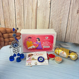 Silver and blue evil eye hand-shaped hanging ornament with dangling bells from evil eye seed rakhi gift hamper for brother
