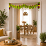 Fabric mango leaf door toran in green with colorful floral accents and small bells for Indian pooja decor