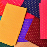 Folded mustard-yellow unstitched floral blouse piece with subtle metallic dot pattern for saree and indian gifts