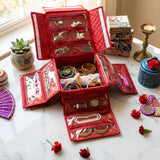 Red quilted handmade jewelry organizer cloth bag with transparent zippered pockets holding gold and pearl accessories