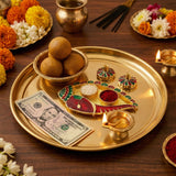 Golden ornate fish-shaped offering tray with red and green enamel accents for indian festival pooja and wedding favor