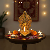 Golden Ganesha brass diya idol with intricate carvings and ornate frame