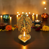 Golden intricately engraved Ganesha brass oil lamp diya with lit candle