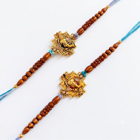 Designer ganesha rakhi with golden elephant charms on wooden beads and blue purple cords for raksha bandhan gift