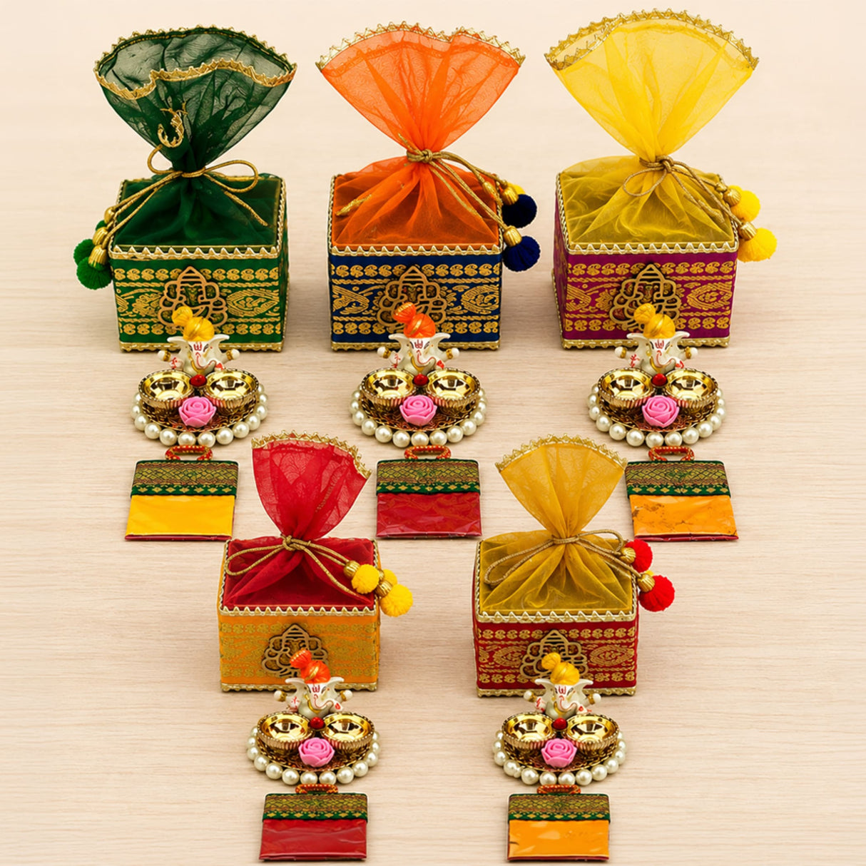 Colorful embroidered potli gift boxes with sheer organza drawstrings and pom-poms for Ganesh Chaturthi and Diwali gifts