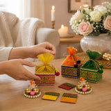 Gold and red ornate embroidered potli gift boxes with drawstring tops for Ganesh Chaturthi and Diwali return gifts