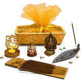 Gold-colored ornate acrylic incense stick holder with intricate cut-out patterns and lit candle for ganesh chaturthi puja