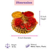 Gold-colored decorative tray with red fabric roses holding yellow and red powders for ganesha gift hamper puja use