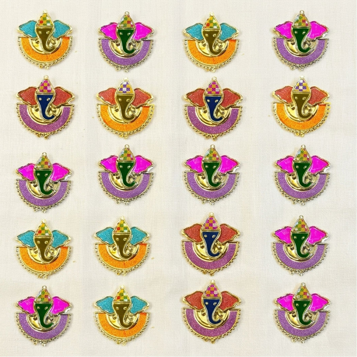 Colorful glittery ganesha-themed decorative appliqués with gold trim and vibrant enamel for indian festival favors
