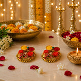 Pack of 4 golden diya pooja holders with intricate floral bell designs holding red and yellow haldi kumkum powders