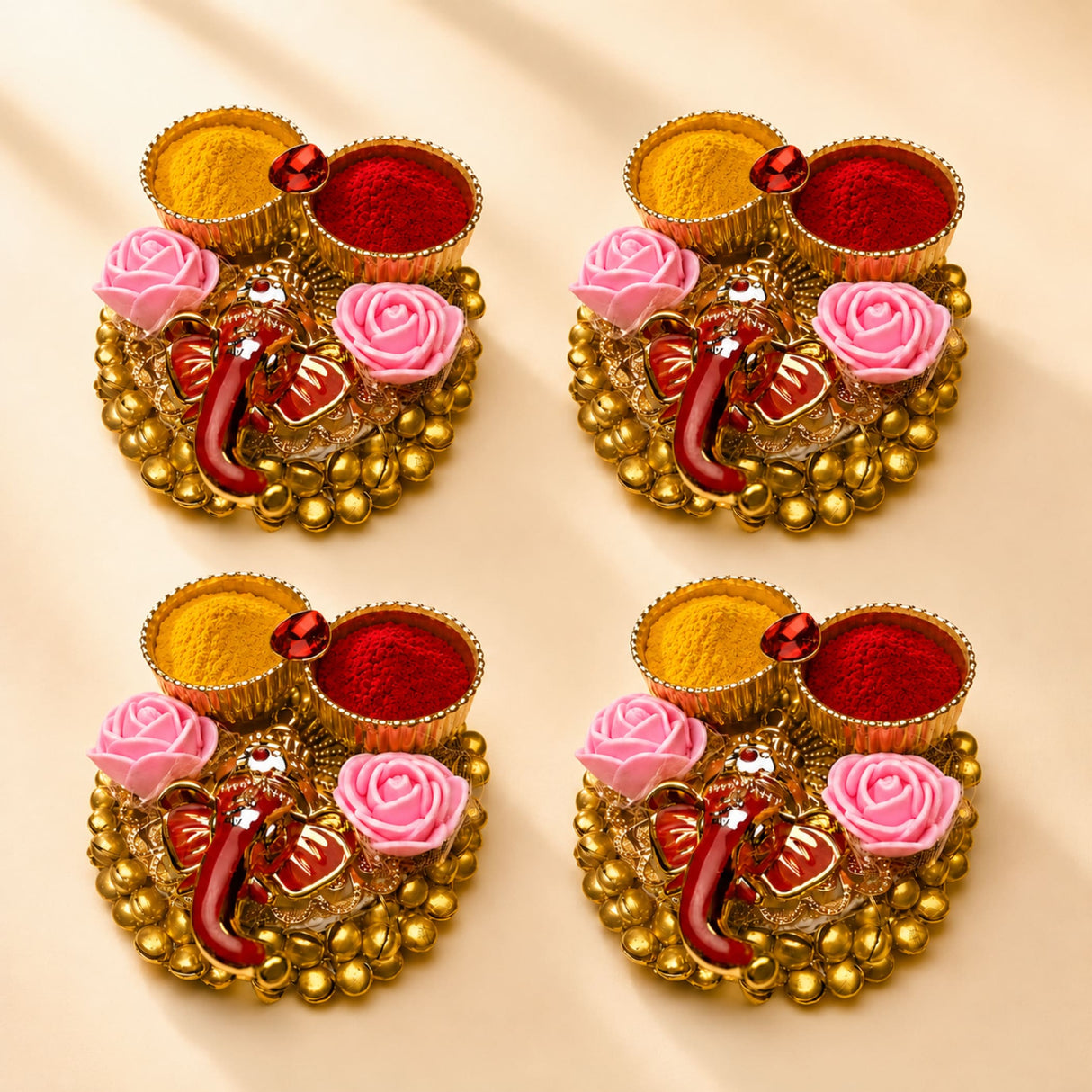 Pack of 4 golden ganesha-themed haldi kumkum holders with pink roses and red yellow powders for pooja gifts