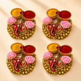 Pack of 4 golden ganesha-themed haldi kumkum holders with pink roses and red yellow powders for pooja gifts
